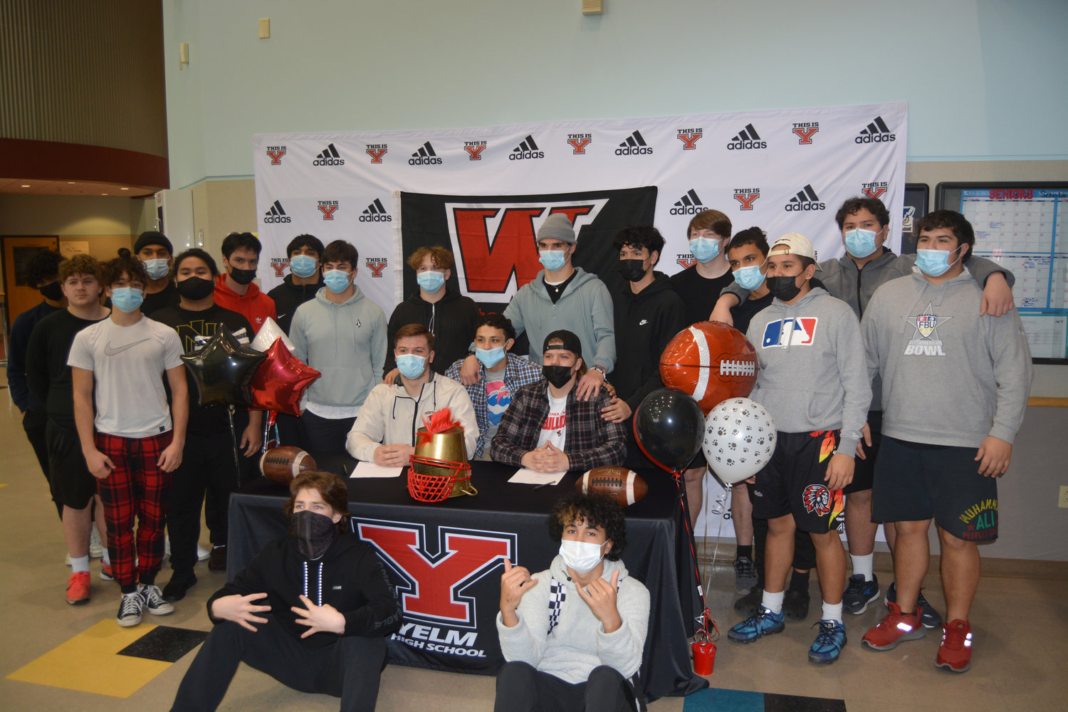 Kollin Gifford and Cooper Cleveringa are joined by members of the 2021 Yelm High School football team at a signing event on Feb. 2.